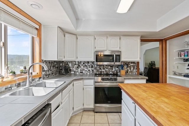 11510 E 20th Ave, Spokane Valley, WA 99206 - kitchen featuring stainless steel appliances, a sink, white cabinets, and tasteful backsplash