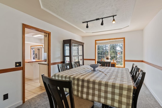 11510 E 20th Ave, Spokane Valley, WA 99206 - dining room with track lighting, a textured ceiling, light tile patterned floors, light carpet, and a tray ceiling
