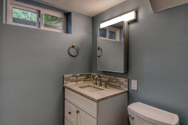 17614 N Palomino Rd, Colbert, WA 99005 - half bathroom with decorative backsplash, toilet, vanity, and a textured wall