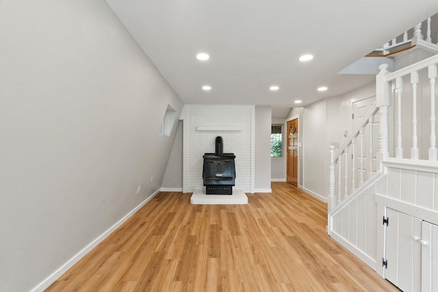 4053 Hanleys Hvn, Loon Lake, WA 99148 - unfurnished living room with a wood stove, light wood-style floors, baseboards, recessed lighting, and stairway