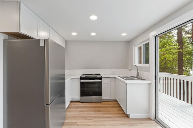 4053 Hanleys Hvn, Loon Lake, WA 99148 - kitchen featuring stainless steel appliances, a sink, light wood-type flooring, light countertops, and white cabinetry