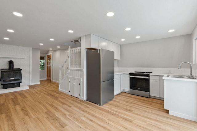 4053 Hanleys Hvn, Loon Lake, WA 99148 - kitchen with stainless steel appliances, a sink, light wood-type flooring, a wood stove, and recessed lighting