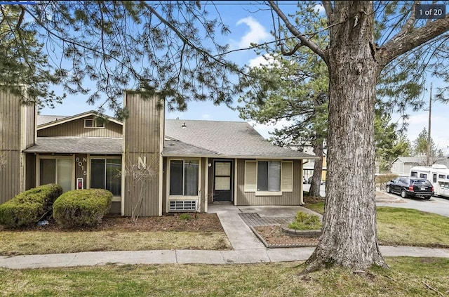6015 E 6th Ave Apt N2, Spokane Valley, WA 99212 - view of front of house with a shingled roof, a chimney, and a front lawn