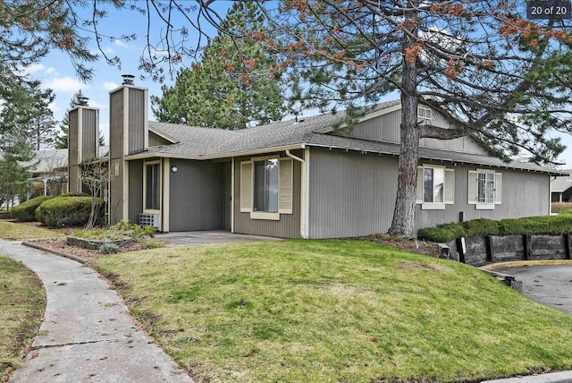 6015 E 6th Ave Apt N2, Spokane Valley, WA 99212 - view of property exterior with a chimney, a lawn, a shingled roof, and a patio area