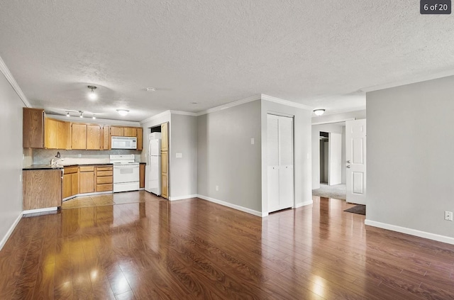 6015 E 6th Ave Apt N2, Spokane Valley, WA 99212 - kitchen featuring white appliances, a textured ceiling, dark wood-type flooring, baseboards, and crown molding