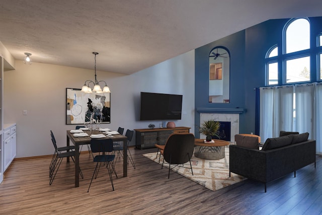 3023 S Winthrop Ln, Spokane, WA 99203 - dining space featuring wood finished floors, a chandelier, a high end fireplace, a textured ceiling, and baseboards