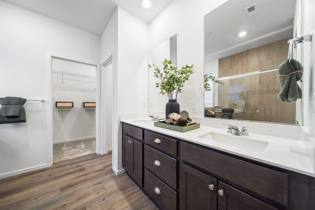 16393 E 30th Ln, Spokane Valley, WA 99037 - bathroom with a shower stall, double vanity, wood finished floors, and a walk in closet