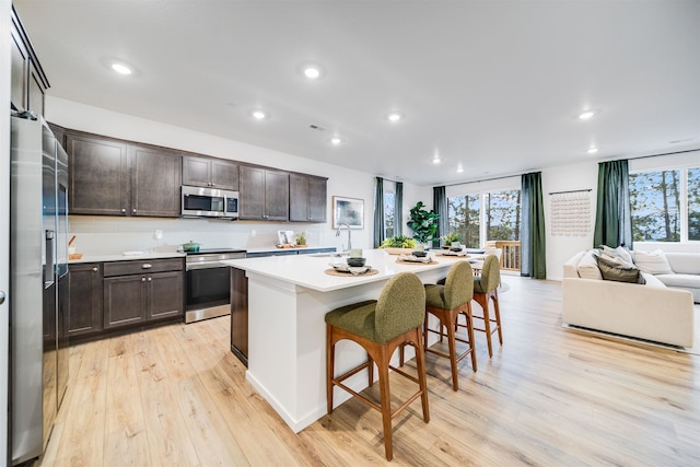 16393 E 30th Ln, Spokane Valley, WA 99037 - kitchen with stainless steel appliances, light wood finished floors, dark brown cabinetry, a breakfast bar area, and recessed lighting
