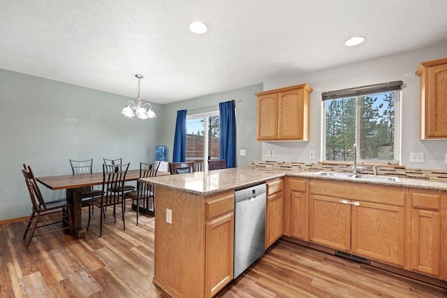 6831 N Cambridge Ln, Spokane, WA 99208 - kitchen with stainless steel dishwasher, a sink, light wood-type flooring, a peninsula, and a chandelier