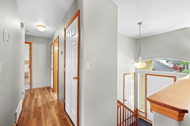 6831 N Cambridge Ln, Spokane, WA 99208 - corridor featuring wood finished floors, an upstairs landing, baseboards, and a textured ceiling