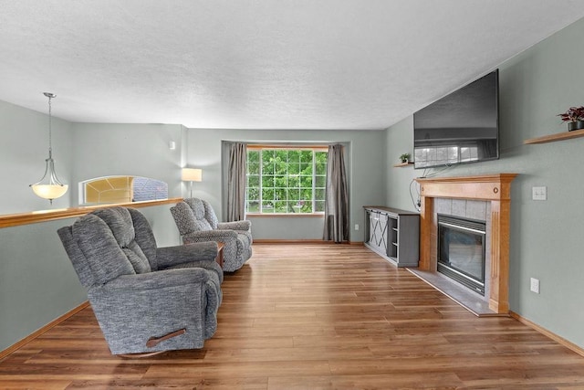 6831 N Cambridge Ln, Spokane, WA 99208 - living area featuring wood finished floors, baseboards, a fireplace, and a textured ceiling