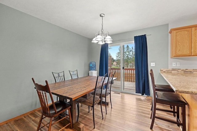 6831 N Cambridge Ln, Spokane, WA 99208 - dining room featuring a chandelier, light wood-type flooring, and baseboards