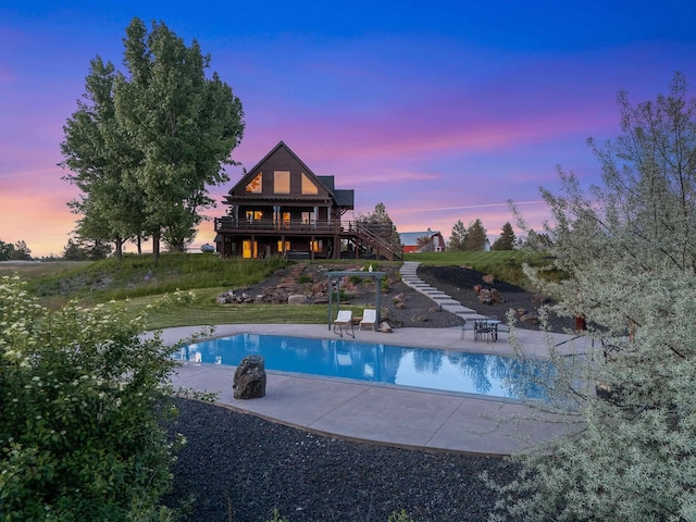 16010 W Jade Ln, Medical Lake, WA 99022 - pool at dusk with a patio, stairs, an outdoor pool, and a deck