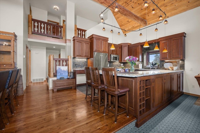 16010 W Jade Ln, Medical Lake, WA 99022 - kitchen with appliances with stainless steel finishes, wood ceiling with exposed beams, high vaulted ceiling, backsplash, and dark wood finished floors