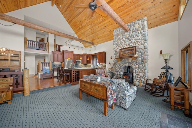 16010 W Jade Ln, Medical Lake, WA 99022 - living room with high vaulted ceiling, a wood stove, carpet flooring, and wooden ceiling with exposed beams