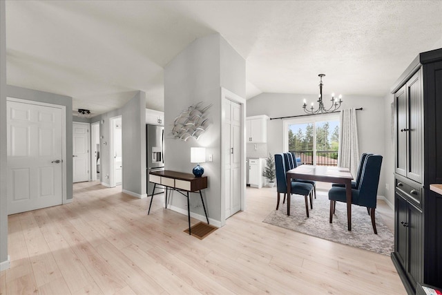 3815 E 19th Ave, Spokane, WA 99223 - dining room featuring a chandelier, lofted ceiling, light wood-style floors, and baseboards