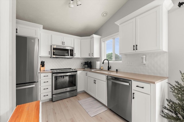 3815 E 19th Ave, Spokane, WA 99223 - kitchen with appliances with stainless steel finishes, a sink, backsplash, light countertops, and white cabinets