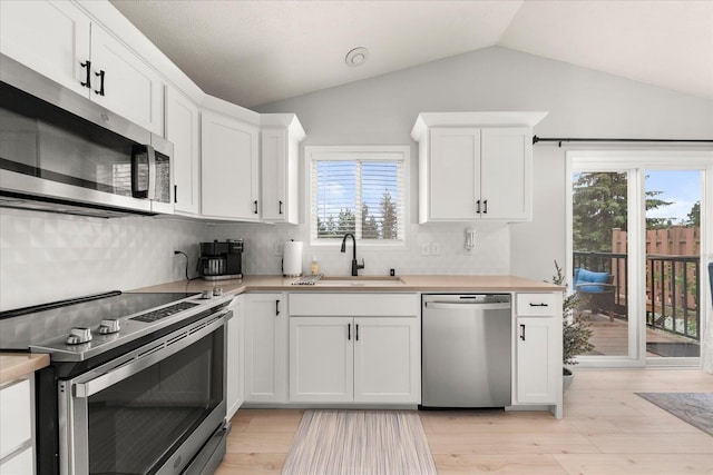 3815 E 19th Ave, Spokane, WA 99223 - kitchen featuring appliances with stainless steel finishes, a sink, light countertops, and lofted ceiling
