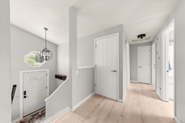 3815 E 19th Ave, Spokane, WA 99223 - foyer with light wood finished floors, a chandelier, baseboards, a textured ceiling, and vaulted ceiling