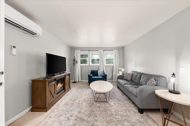 3815 E 19th Ave, Spokane, WA 99223 - living area featuring a wall mounted air conditioner, baseboards, light wood-style floors, and a glass covered fireplace