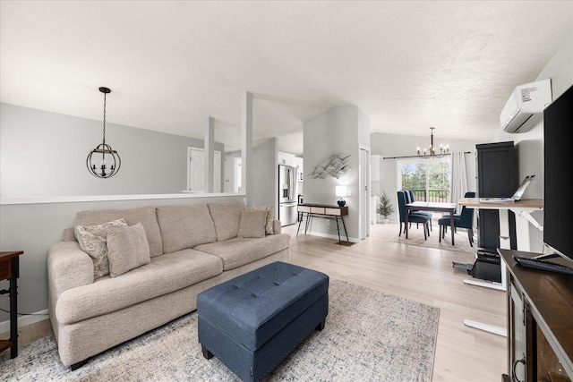 3815 E 19th Ave, Spokane, WA 99223 - living area featuring a chandelier, a wall mounted air conditioner, light wood-type flooring, and baseboards