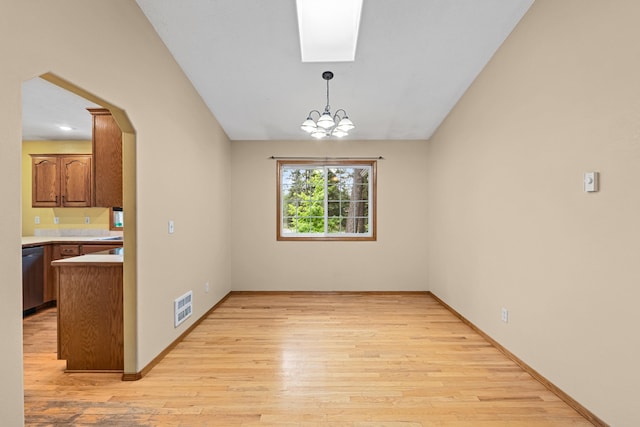 525 Quail Loop, Newport, WA 99156 - empty room with light wood finished floors, arched walkways, vaulted ceiling, a chandelier, and baseboards