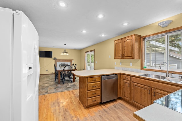 525 Quail Loop, Newport, WA 99156 - kitchen featuring white fridge with ice dispenser, dishwasher, a sink, brown cabinets, and recessed lighting