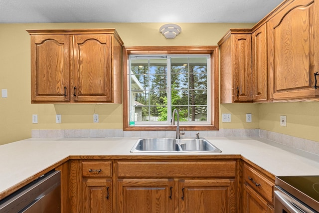 525 Quail Loop, Newport, WA 99156 - kitchen featuring a sink, stainless steel dishwasher, light countertops, and brown cabinets