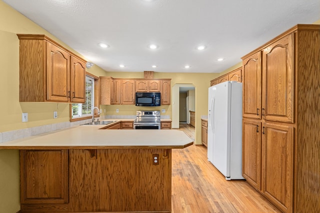 525 Quail Loop, Newport, WA 99156 - kitchen featuring black microwave, white refrigerator with ice dispenser, stainless steel range with electric cooktop, a sink, and a peninsula