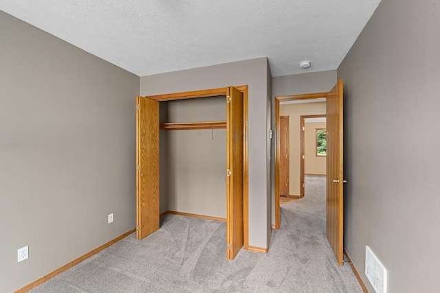 525 Quail Loop, Newport, WA 99156 - unfurnished bedroom featuring light carpet, baseboards, a closet, and a textured ceiling