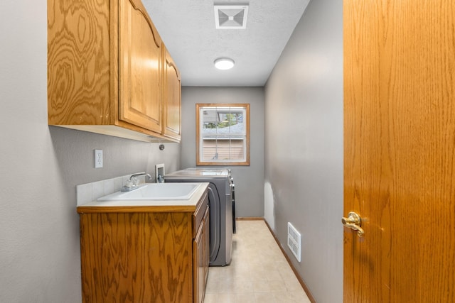 525 Quail Loop, Newport, WA 99156 - laundry room with cabinet space, washing machine and clothes dryer, a textured ceiling, baseboards, and light tile patterned floors