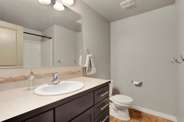 1105 S Oswald St, Spokane, WA 99224 - bathroom featuring wood finished floors, vanity, baseboards, toilet, and a shower