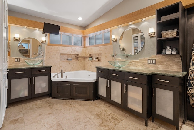220 W Evergreen Dr, Kettle Falls, WA 99141 - full bathroom featuring vaulted ceiling, two vanities, a bath, and decorative backsplash