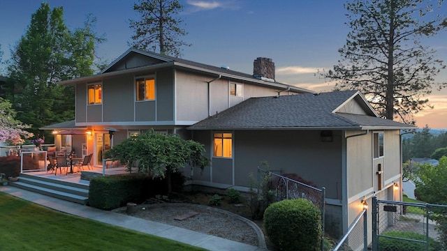 2205 S Conklin Rd, Spokane Valley, WA 99037 - back of property at dusk featuring a chimney, a deck, and roof with shingles