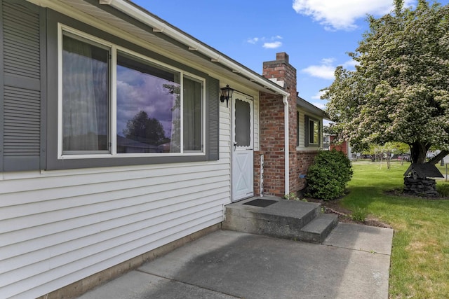 13304 E Desmet Ave, Spokane Valley, WA 99216 - entrance to property featuring a chimney, a lawn, brick siding, and a patio