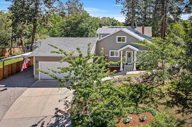 903 E 11th Ave, Spokane, WA 99202 - view of front of house with concrete driveway, a shingled roof, an attached garage, a carport, and view of wooded area