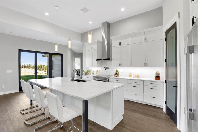 5110 W Hayden Ln, Spokane, WA 99208 - kitchen featuring a sink, wall chimney exhaust hood, a kitchen island with sink, white cabinets, and dark wood finished floors