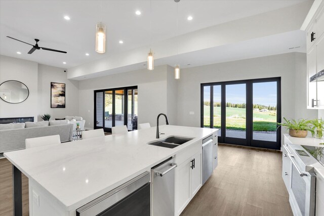 5110 W Hayden Ln, Spokane, WA 99208 - kitchen featuring a sink, light wood-style flooring, a kitchen island with sink, open floor plan, and recessed lighting