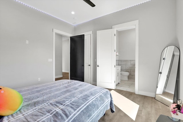 5110 W Hayden Ln, Spokane, WA 99208 - bedroom featuring light wood finished floors, ensuite bath, and tile walls