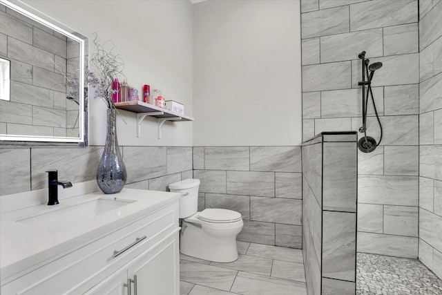 5110 W Hayden Ln, Spokane, WA 99208 - bathroom with tiled shower, vanity, toilet, and tile walls