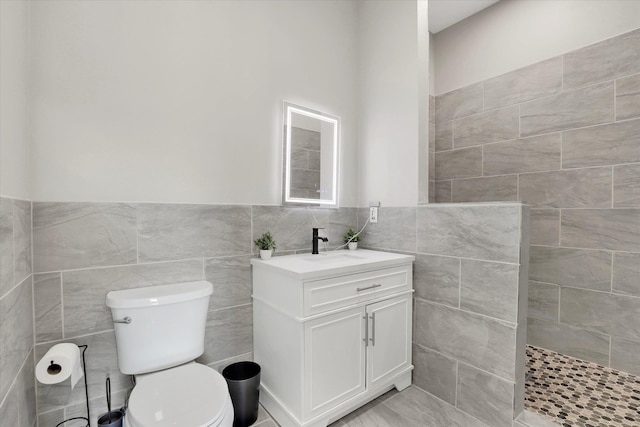 5110 W Hayden Ln, Spokane, WA 99208 - bathroom with tile walls, toilet, vanity, walk in shower, and a wainscoted wall
