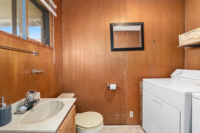 705 Old Kettle Rd, Kettle Falls, WA 99114 - half bathroom featuring separate washer and dryer, toilet, wooden walls, and vanity