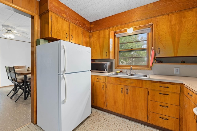 705 Old Kettle Rd, Kettle Falls, WA 99114 - kitchen with freestanding refrigerator, stainless steel microwave, a sink, and light floors