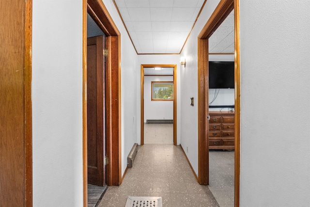 705 Old Kettle Rd, Kettle Falls, WA 99114 - hall with a baseboard radiator, baseboards, tile patterned floors, and crown molding