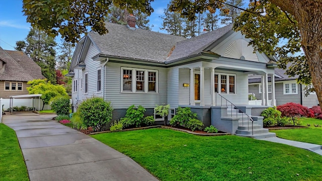 112 E 22nd Ave, Spokane, WA 99203 - bungalow featuring covered porch, a front lawn, a shingled roof, concrete driveway, and a chimney
