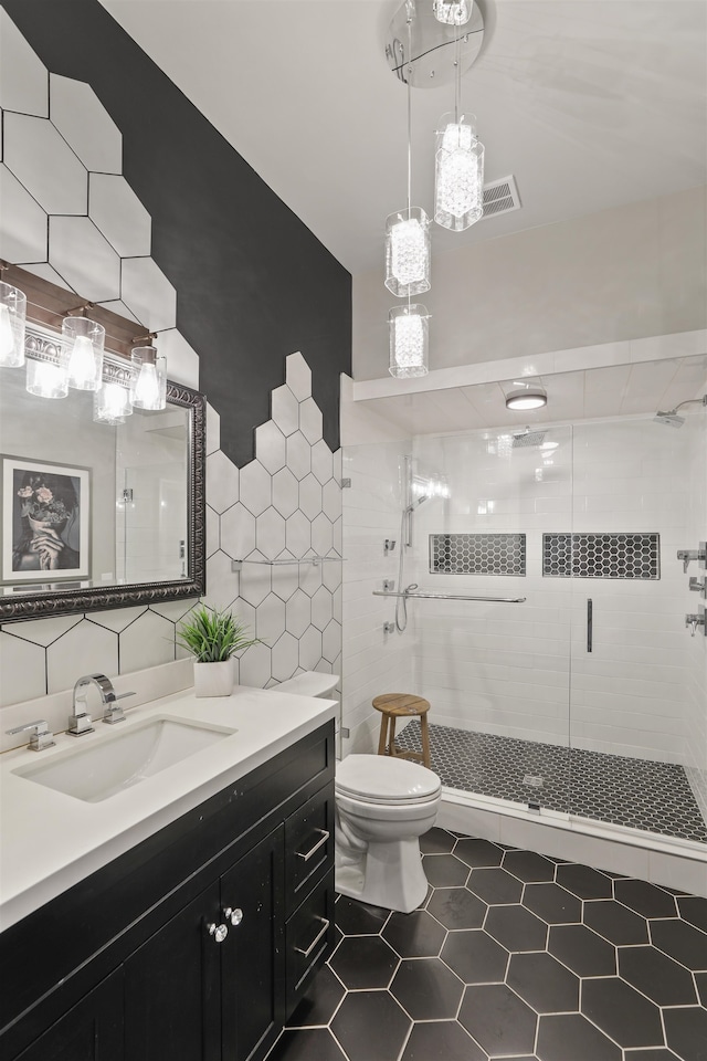 423 W 1st Ave Unit 110, Spokane, WA 99201 - full bathroom featuring toilet, vanity, a stall shower, tile walls, and tile patterned flooring