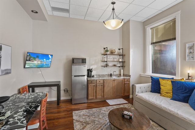 423 W 1st Ave Unit 110, Spokane, WA 99201 - living room featuring dark wood-type flooring, wet bar, a paneled ceiling, and baseboards