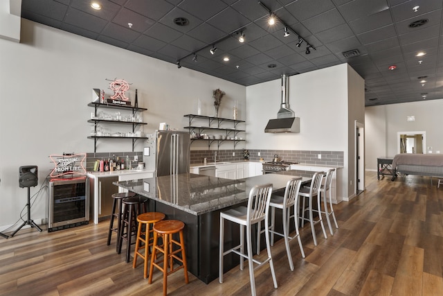 423 W 1st Ave Unit 110, Spokane, WA 99201 - kitchen with track lighting, appliances with stainless steel finishes, open shelves, wood finished floors, and tasteful backsplash
