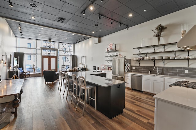 423 W 1st Ave Unit 110, Spokane, WA 99201 - kitchen featuring track lighting, appliances with stainless steel finishes, a sink, dark wood finished floors, and white cabinets