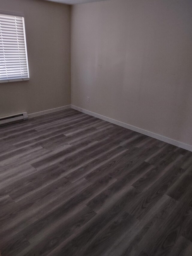108 E Weile Ave # 1, Spokane, WA 99208 - unfurnished room with baseboards, a baseboard heating unit, and dark wood-style flooring